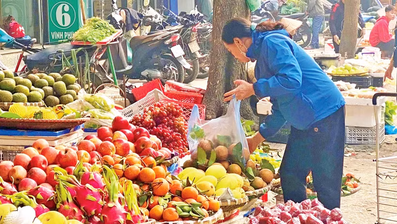 Người dân mua hoa quả tại chợ Vĩnh Phúc (quận Ba Đình, Hà Nội). 