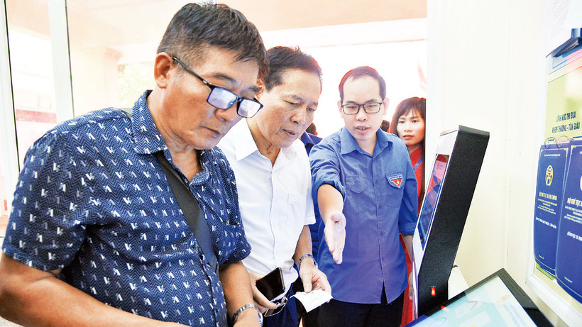 Cán bộ đoàn phường Trung Văn hướng dẫn người dân làm thủ tục hành chính tại bộ phận một cửa. 