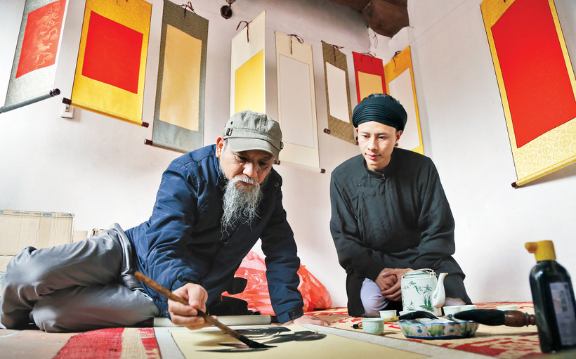 Họa sĩ Phan Cẩm Thượng viết thư pháp nhân một lần du xuân. Ảnh trong bài: Khiếu Minh 