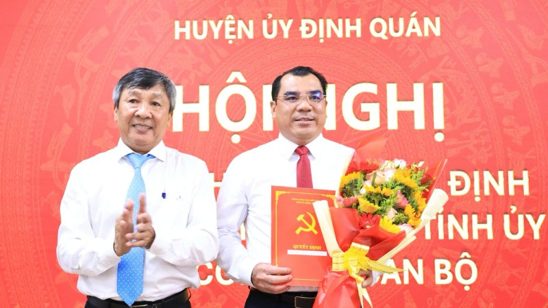 Phó Bí thư Thường trực Tỉnh ủy Hồ Thanh Sơn trao quyết định và tặng hoa chúc mừng tân Bí thư Huyện ủy Định Quán.