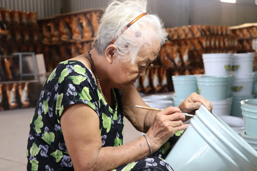 Một người thợ cao tuổi khắc hoa văn lên sản phẩm gốm Biên Hòa.