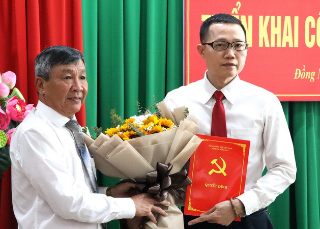 Phó Bí thư Thường trực Tỉnh ủy Đồng Nai Hồ Thanh Sơn trao quyết định và tặng hoa chúc mừng đồng chí Nguyễn Phong An.