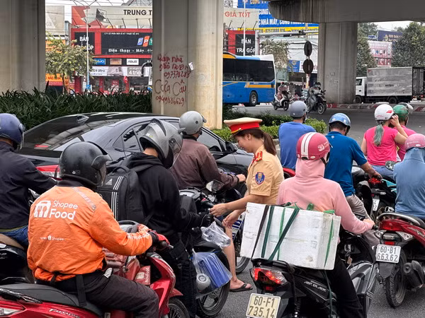 Nữ cảnh sát giao thông Công an tỉnh Đồng Nai phát nước suối cho người dân về quê đón Tết. 