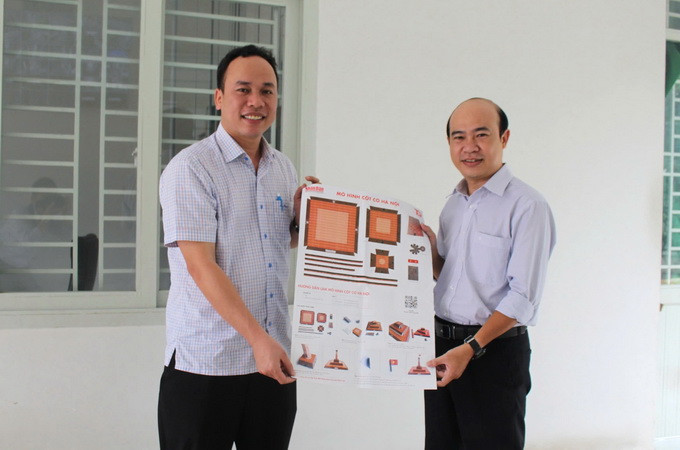 Đại diện Ban Giám hiệu Trường trung học cơ sở Nguyễn Bỉnh Khiêm tiếp nhận phụ san Báo Nhân Dân về Cột cờ Hà Nội.