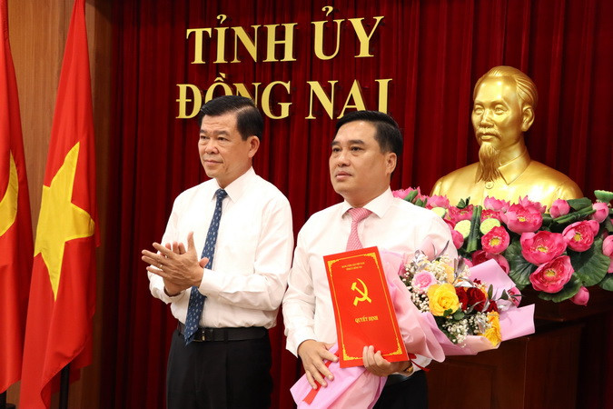 Bí thư Tỉnh ủy Đồng Nai Nguyễn Hồng Lĩnh trao quyết định và tặng hoa chúc mừng đồng chí Hồ Văn Nam.