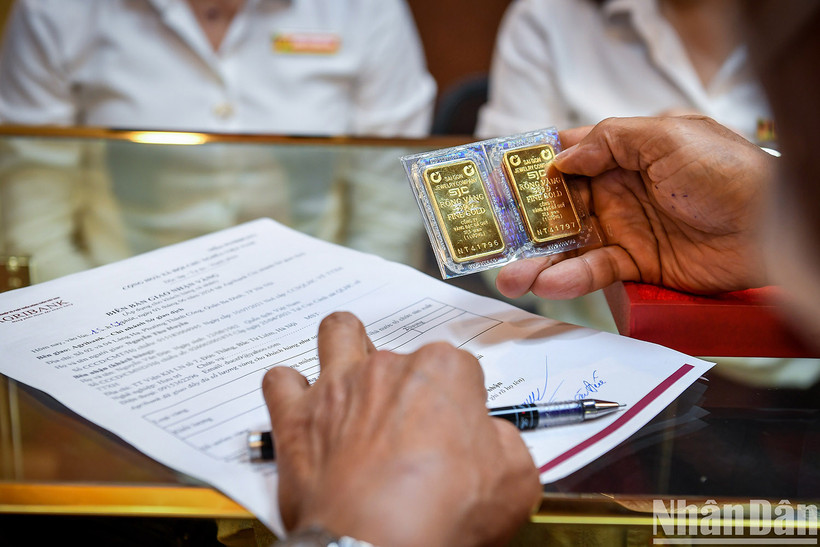 Người dân nhận vàng tại ngân hàng Agribank trong ngày đầu tiên ngân hàng này mở bán vàng đến người dân. (Ảnh: THÀNH ĐẠT)