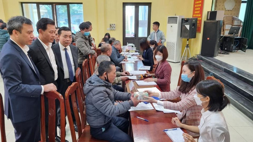 Người dân xã Song Phương đến nhận tiền hỗ trợ bồi thường.