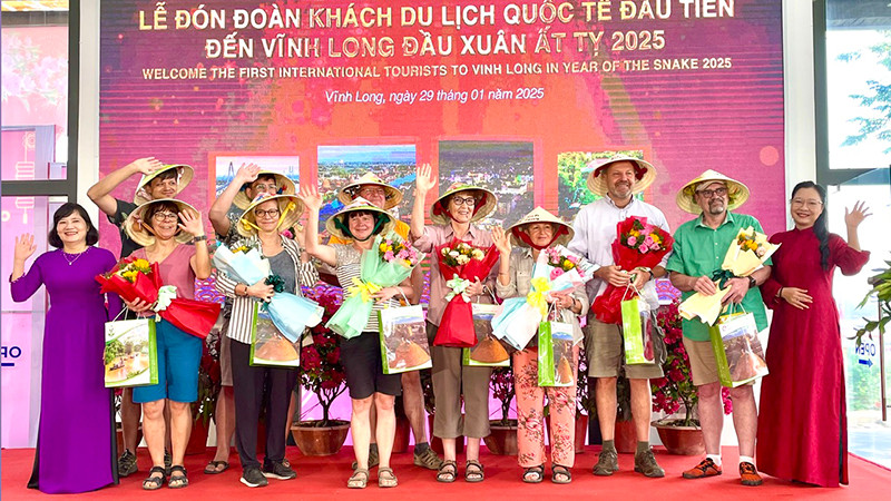 Lãnh đạo tỉnh Vĩnh Long tặng quà và hoa cho khách du lịch quốc tế đầu tiên. 