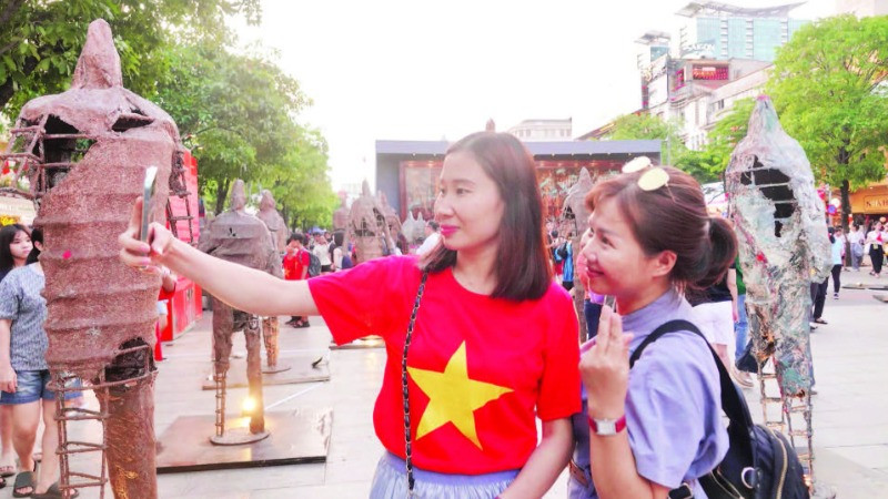 Du khách thích thú với các hoạt động trong chuỗi sự kiện “Sắc màu thành phố Bác” tại đường đi bộ Nguyễn Huệ. (Ảnh MẠNH HẢO)