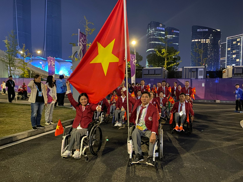 Kình ngư Võ Thanh Tùng (bên phải) vinh dự cầm cờ Việt Nam tại lễ khai mạc Asian Para Games 4.