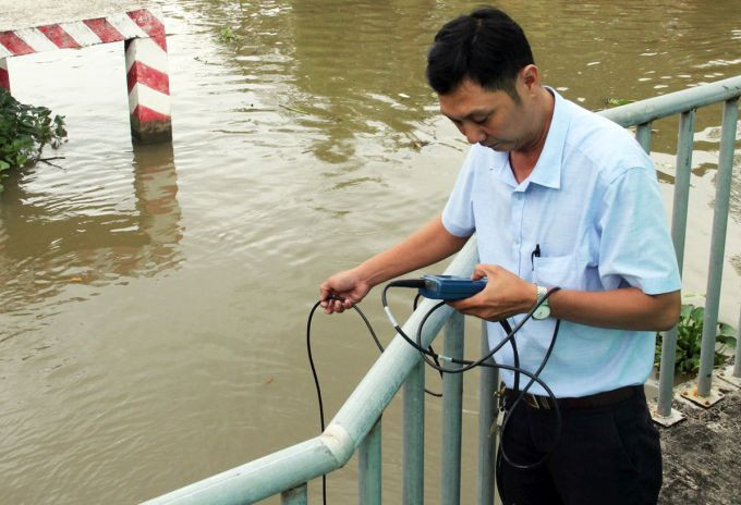 Cán bộ nông nghiệp kiểm tra độ mặn trên kênh tại Bạc Liêu. Ảnh: Cửu Long