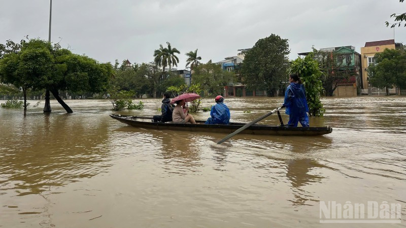 Ngập sâu, người dân di chuyển bằng thuyền trên đường Bạch Đằng. (Ảnh: Nguyên Quý)