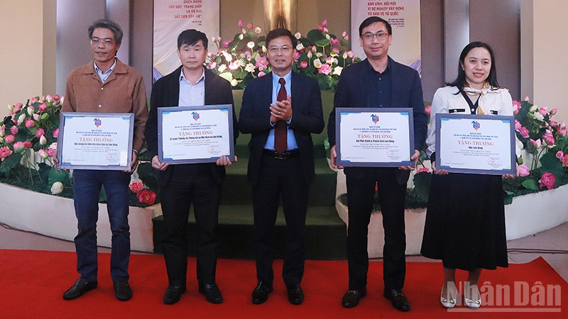 Phóng viên Báo Nhân Dân (bìa trái) nhận khen thưởng của Ban Tổ chức Hội báo và triển lãm mừng 100 năm Báo chí cách mạng Việt Nam. ndo_br_img-7687.jpg