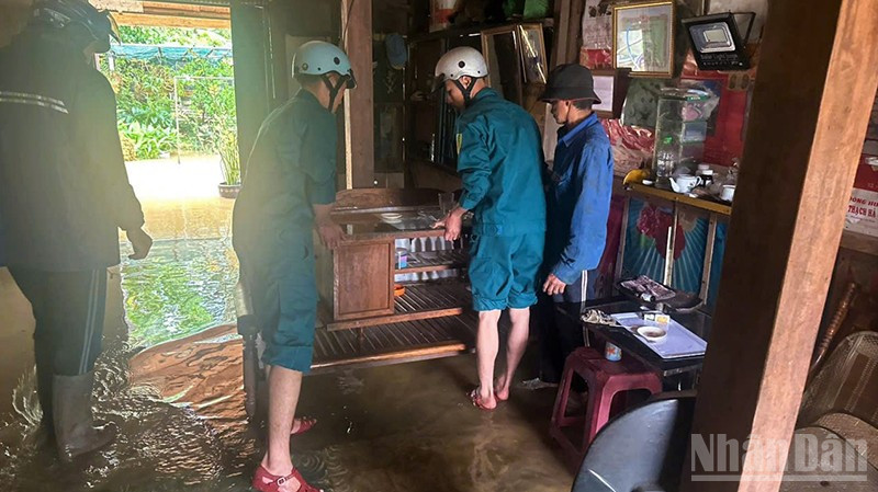 Lực lượng dân quân Phường 3 Bảo Lộc, tỉnh Lâm Đồng hỗ trợ các hộ dân có nhà bị ngập di chuyển đồ đạc, tài sản đến nơi an toàn. ndo_br_tt.jpg