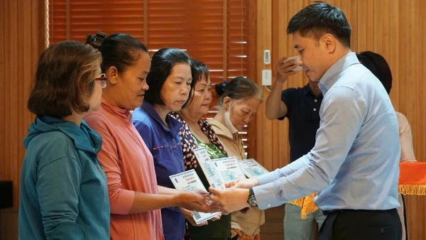 Lãnh đạo Cơ quan Bảo hiểm xã hội Thành phố Hồ Chí Minh tặng thẻ Bảo hiểm y tế cho phụ nữ có hoàn cảnh khó khăn. (Ảnh: VÕ LÊ)