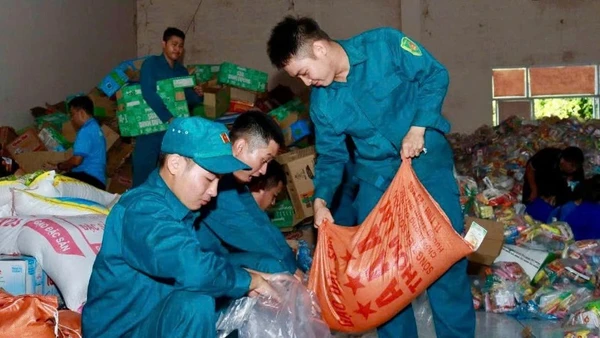 Lực lượng Dân quân tự vệ thuộc Ban chỉ huy Phòng thủ khu vực 2-Phú Lợi chuẩn bị nhu yếu phẩm gửi ra cho bà con bị ảnh hưởng lũ lụt ở miền trung. (Ảnh: VÕ LÊ) 