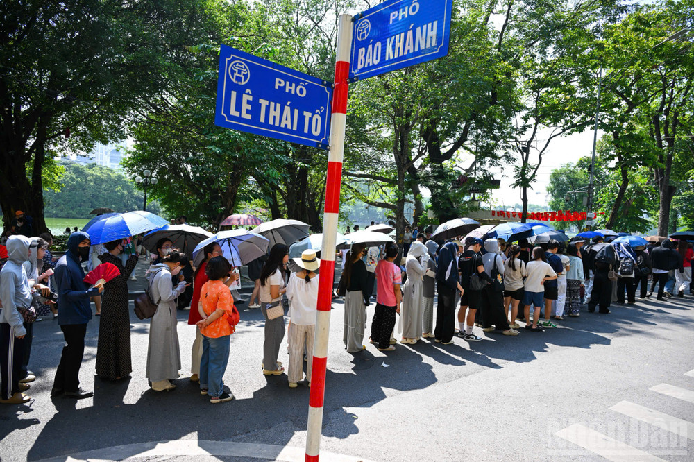 Tại ngã tư phố Lê Thái Tổ và Bảo Khánh, dòng người nối dài trong trật tự, kiên nhẫn chờ đến lượt nhận vé. ndo_br_2.jpg