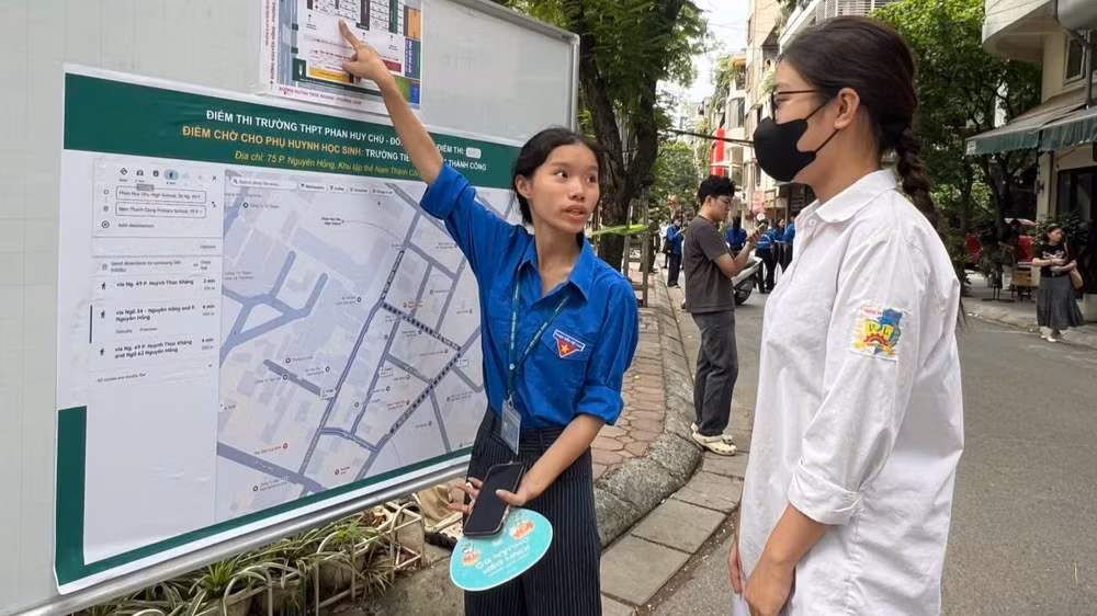 Sinh viên tình nguyện hướng dẫn thí sinh tìm đường đi, phòng thi. (Ảnh: QUỲNH TRANG)