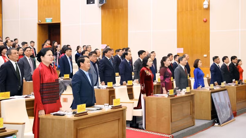 Đại biểu dự kỳ họp thực hiện nghi thức chào cờ.