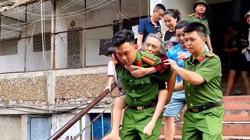 Công an phường Thành Vinh (Nghệ An) hỗ trợ người dân ở các khu chung cư cũ sơ tán để tránh nguy hiểm do mưa bão.