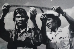Phi công Nguyễn Văn Bảy (trái) cùng đồng đội xem lại những tấm phim do máy ảnh tự động chụp khi điểm hỏa. (Ảnh tư liệu)