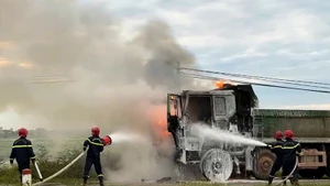 Lực lượng chuyên nghiệp sử dụng thiết bị chuyên dụng dập lửa khu vực cabin xe.