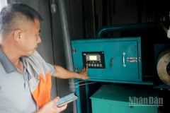 Ông Trần Xuân Phong vận hành máy phát điện từ khí biogas. (Ảnh: TRUNG HƯNG)