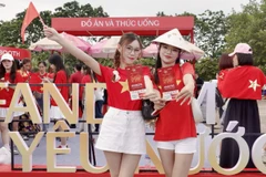 Các bạn trẻ check-in tại gian hàng Fandom Yêu nước với tấm vé chương trình “Tổ Quốc trong tim” trên tay. (Ảnh: BTC)
