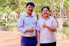 Thí sinh Nguyễn Thái An, học sinh trường THPT Kim Sơn A đạt điểm tuyệt đối 30/30 khối A00 và thầy giáo chủ nhiệm chụp ảnh lưu niệm. (Ảnh: Báo Ninh Bình)
