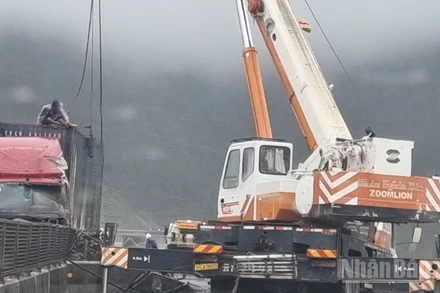 Lực lượng chức năng giải cứu xe bị trơn trượt dẫn tới va chạm do mưa bão số 10 gây ra.