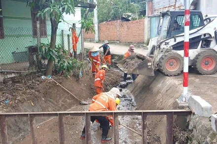 Công nhân bảo dưỡng đường bộ hót dọn cống thực hiện công việc bảo dưỡng thường xuyên.