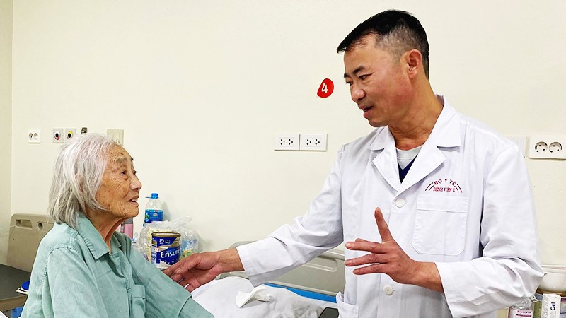 ThS, bác sĩ CKII Kiều Quốc Hiền, Trưởng Khoa A9 (Bệnh viện E) thăm hỏi, hướng dẫn bệnh nhân cao tuổi phục hồi sau mổ. 