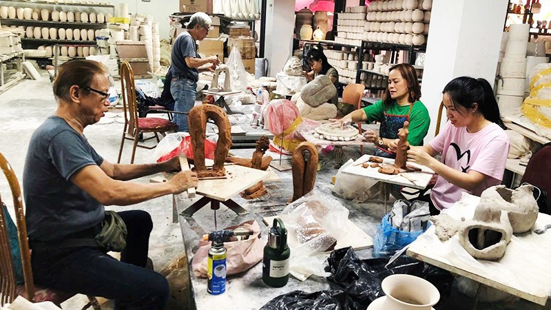 Các nghệ sĩ tạo hình tác phẩm mới trong không gian làng gốm cổ Bát Tràng. Ảnh: THỤY PHƯƠNG