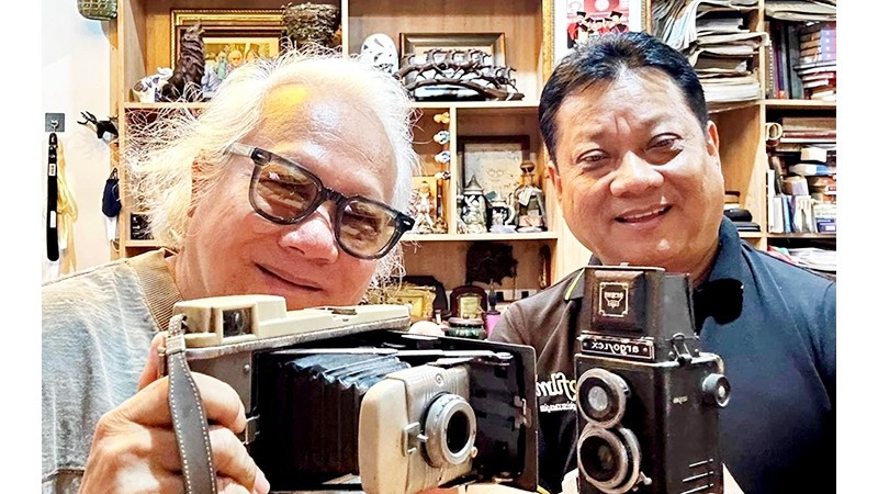 Đạo diễn Xuân Phước (phải) với tác giả bài viết chuẩn bị đạo cụ cho dòng phim xưa. Ảnh tư liệu của người viết