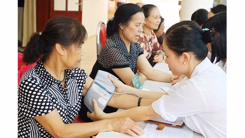 Khám sức khỏe định kỳ cho người dân tại Trạm Y tế phường Nghĩa Đô. Ảnh: HẢI NAM