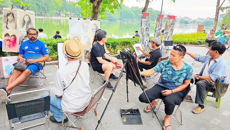 Ký họa chân dung trong không gian phố đi bộ hồ Gươm dịp cuối tuần. Ảnh: HẢI NAM