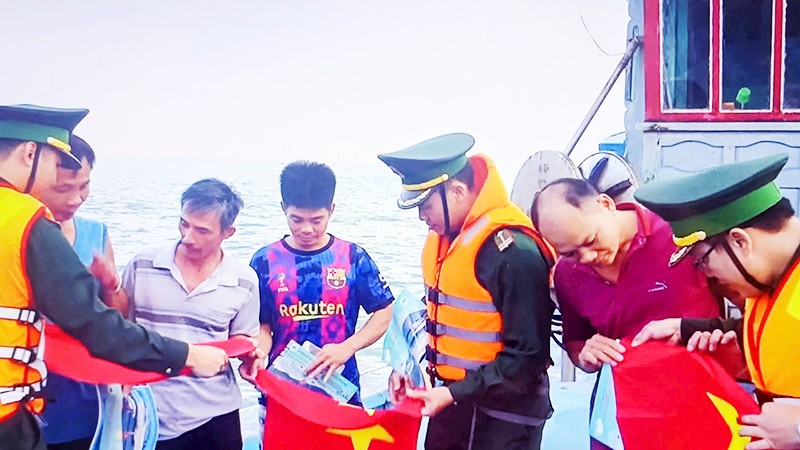 Cán bộ, chiến sĩ Hải đoàn 48 và Bộ Tư lệnh Vùng Cảnh sát biển 2 tặng cờ Tổ quốc cho ngư dân.