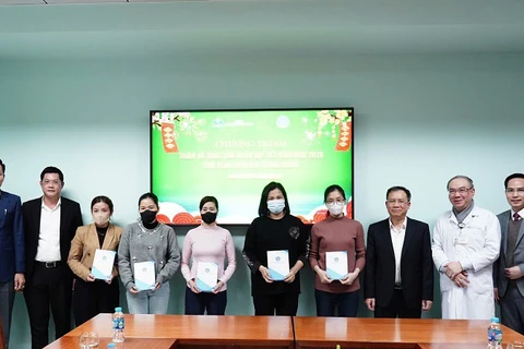 Giám đốc Lê Hùng Sơn tặng quà đại diện bệnh nhân bảo hiểm y tế có hoàn cảnh khó khăn. (Ảnh VSS)