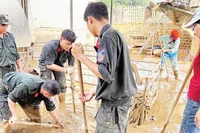 Lực lượng công an, giáo viên và người dân dọn bùn đất sau lũ tại một điểm trường mầm non vùng cao tỉnh Tuyên Quang.