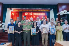 Đại diện các gia đình đón nhận di ảnh anh hùng liệt sĩ tại sự kiện. 