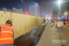 Công nhân thảm lại mặt đường sau khi dỡ bỏ phần quây tôn để trả lại mặt đường cho người tham gia giao thông.