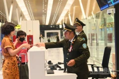 Hành khách thực hiện kiểm tra an ninh trước khi lên máy bay tại sân bay.