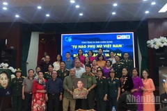 Gia đình Anh hùng Lực lượng vũ trang nhân dân-Liệt sĩ Lê Văn Dỵ trao tặng di ảnh và cuốn sách "Đâu có giặc là ta cứ đi" cho Bảo tàng Phụ nữ Việt Nam.