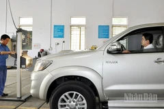 Đăng kiểm viên thực hiện đăng kiểm với một xe ô-tô.