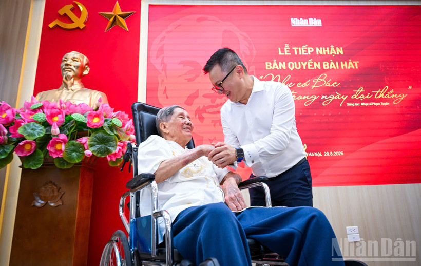 Nhạc sĩ Phạm Tuyên và Tổng Biên tập Báo Nhân Dân Lê Quốc Minh tại buổi lễ tiếp nhận. (Ảnh: THÀNH ĐẠT)