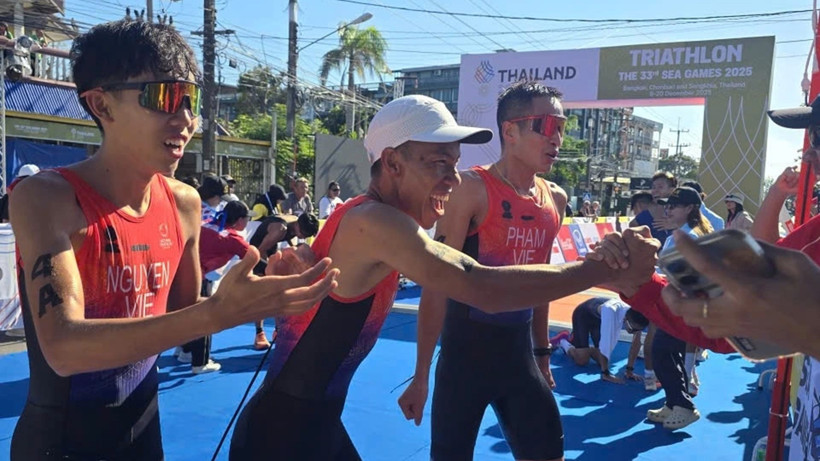 Hoàng Vũ, Anh Trí và Tiến Sản mừng chiến thắng với ban huấn luyện đội tuyển triathlon Việt Nam. (Ảnh: VTF)