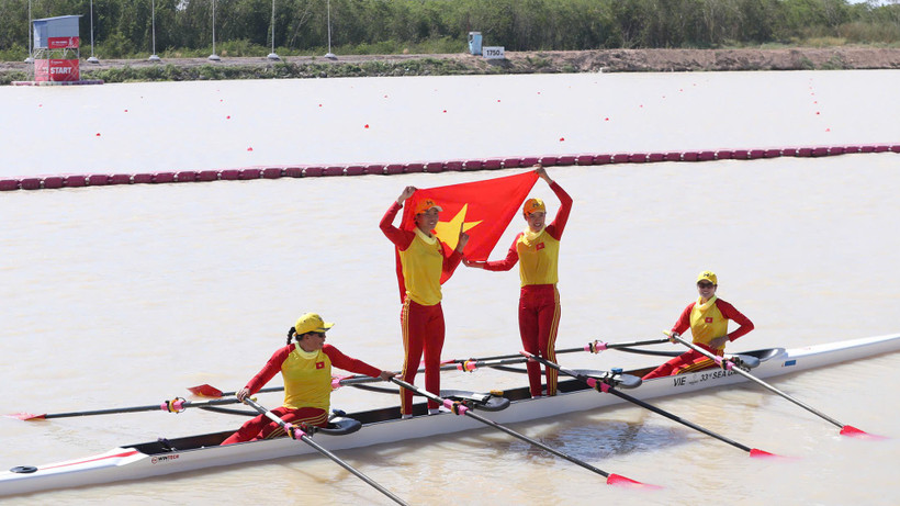Các tay chèo Việt Nam tự hào giương cao quốc kỳ sau khi cán đích về nhất. 