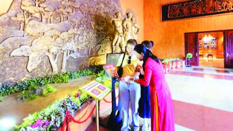 Du khách tìm hiểu Bảo tàng Quang Trung thông qua việc quét mã QR, quét NFC. (Ảnh: MINH PHÚC)