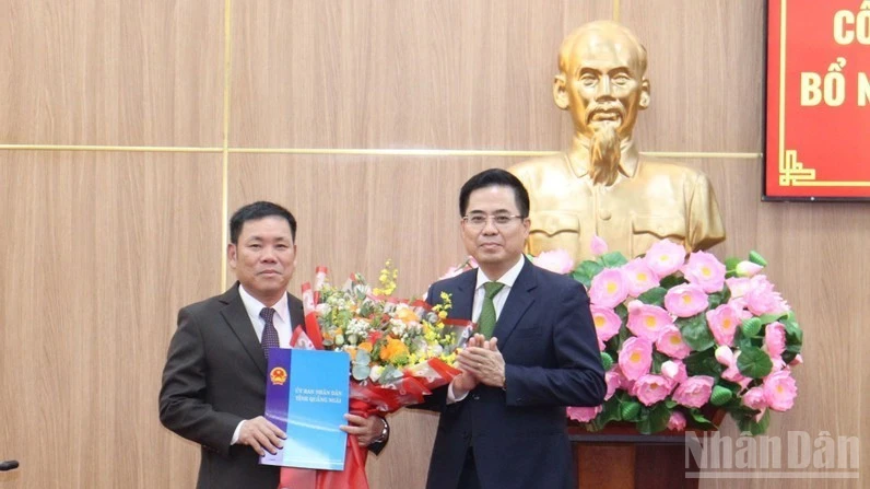 Chủ tịch Ủy ban nhân dân tỉnh Quảng Ngãi Nguyễn Hoàng Giang trao quyết định và tặng hoa chúc mừng đồng chí Nguyễn Văn Trọng.