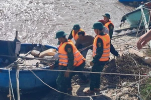 Bộ đội biên phòng hỗ trợ ngư dân kéo tàu lên.